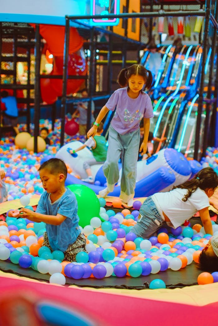 Children having fun in a colorful indoor ball pit playground.